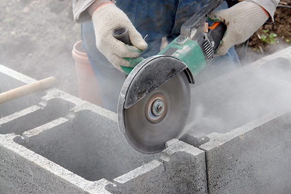 Using a grinder to cut cement blocks without water or dust extraction creates silica dust.