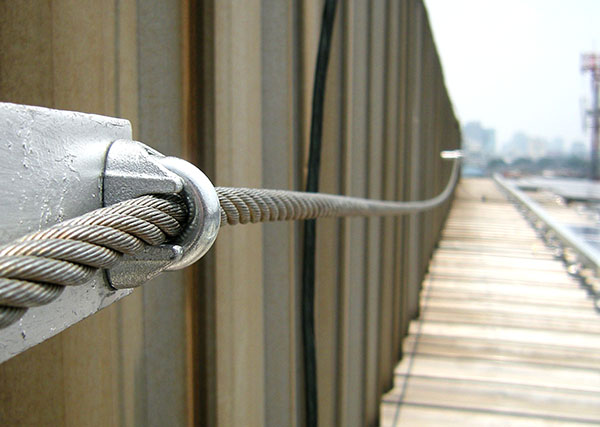 The placement of a steel wire rope sling lifeline on the roof ensures safety working at heights during maintenance tasks.